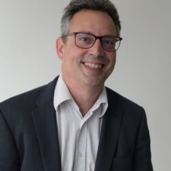 Représente un homme, souriant, avec des lunette - Agrandir l'image, fenêtre modale